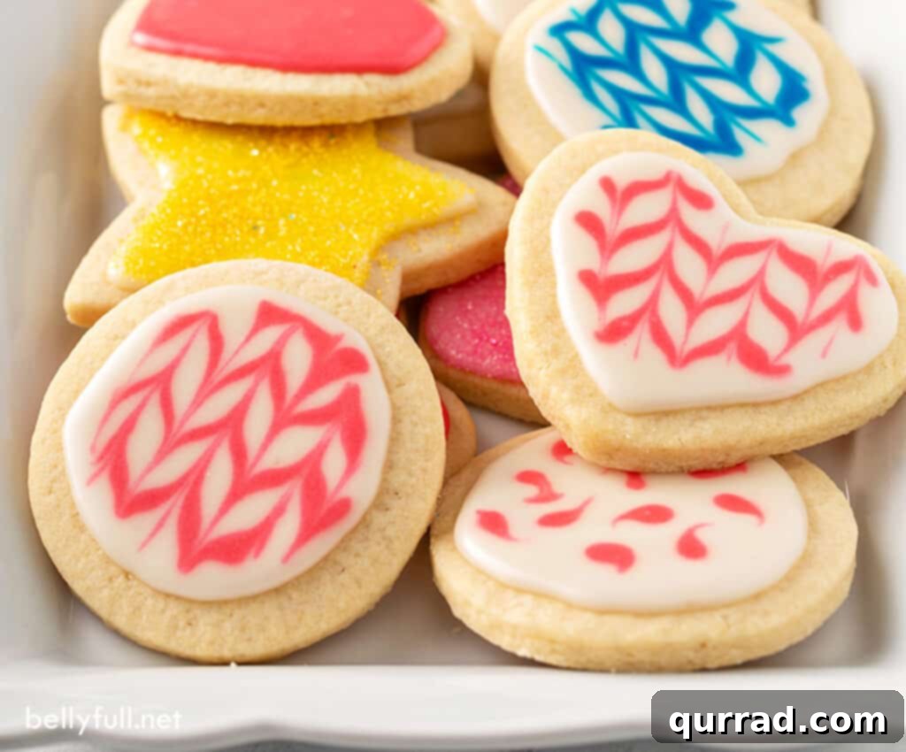 Flawless Sugar Cookie Icing 5 cut out sugar cookies decorated in pink icing, showcasing easy sugar cookie decorating