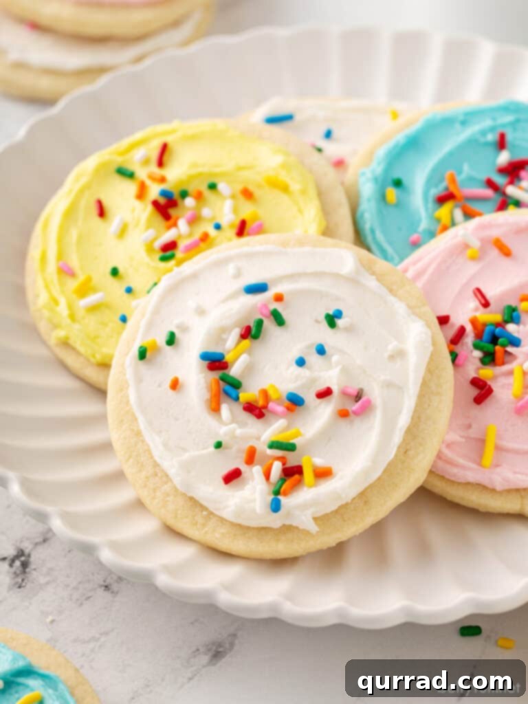 Best Sugar Cookie Frosting 2 Delicious sugar cookie with white frosting and colorful sprinkles on a plate, ready to be enjoyed.