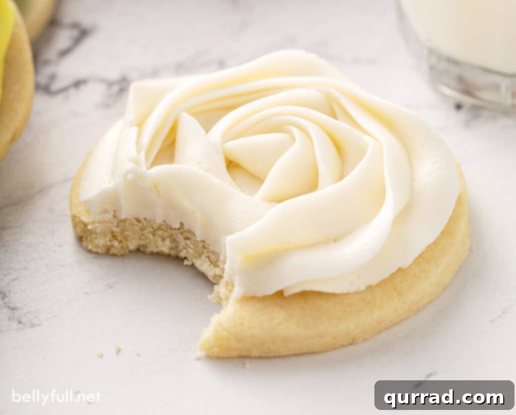 Best Sugar Cookie Frosting 5 Close-up of a sugar cookie with elegantly piped white frosting, showcasing its smooth texture.