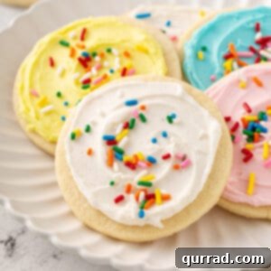 cookie with white sugar cookie frosting and sprinkles on plate