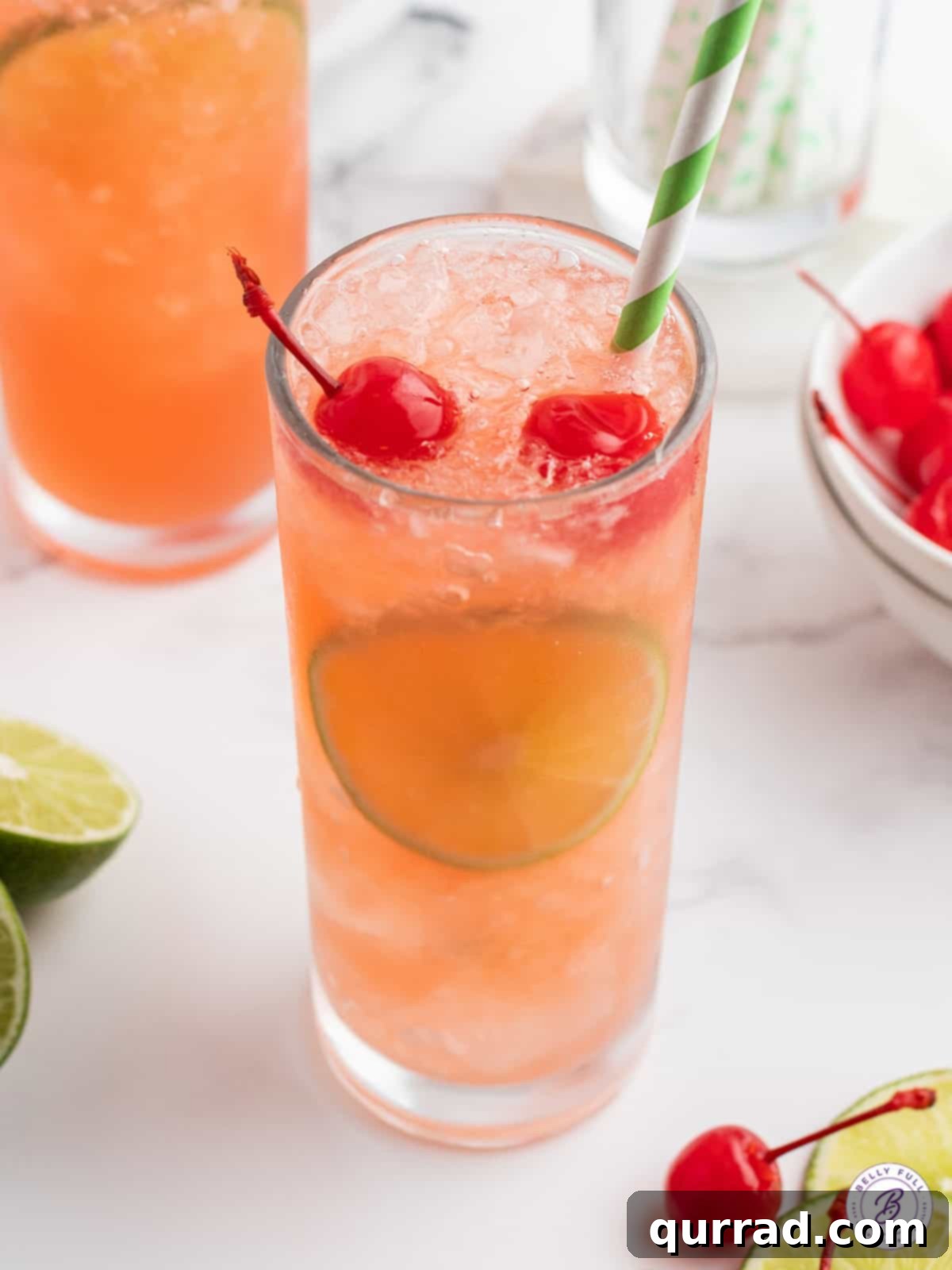 Sparkling Cherry Limeade 2 A vibrant glass of homemade Cherry Limeade with a straw and fresh lime slices, ready to be enjoyed.