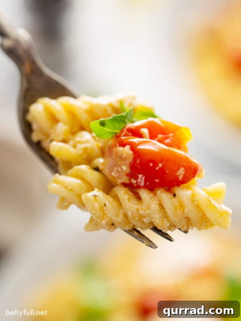 Creamy Tomato Feta Pasta Bake 6 close up rotini pasta with roasted cherry tomato on fork