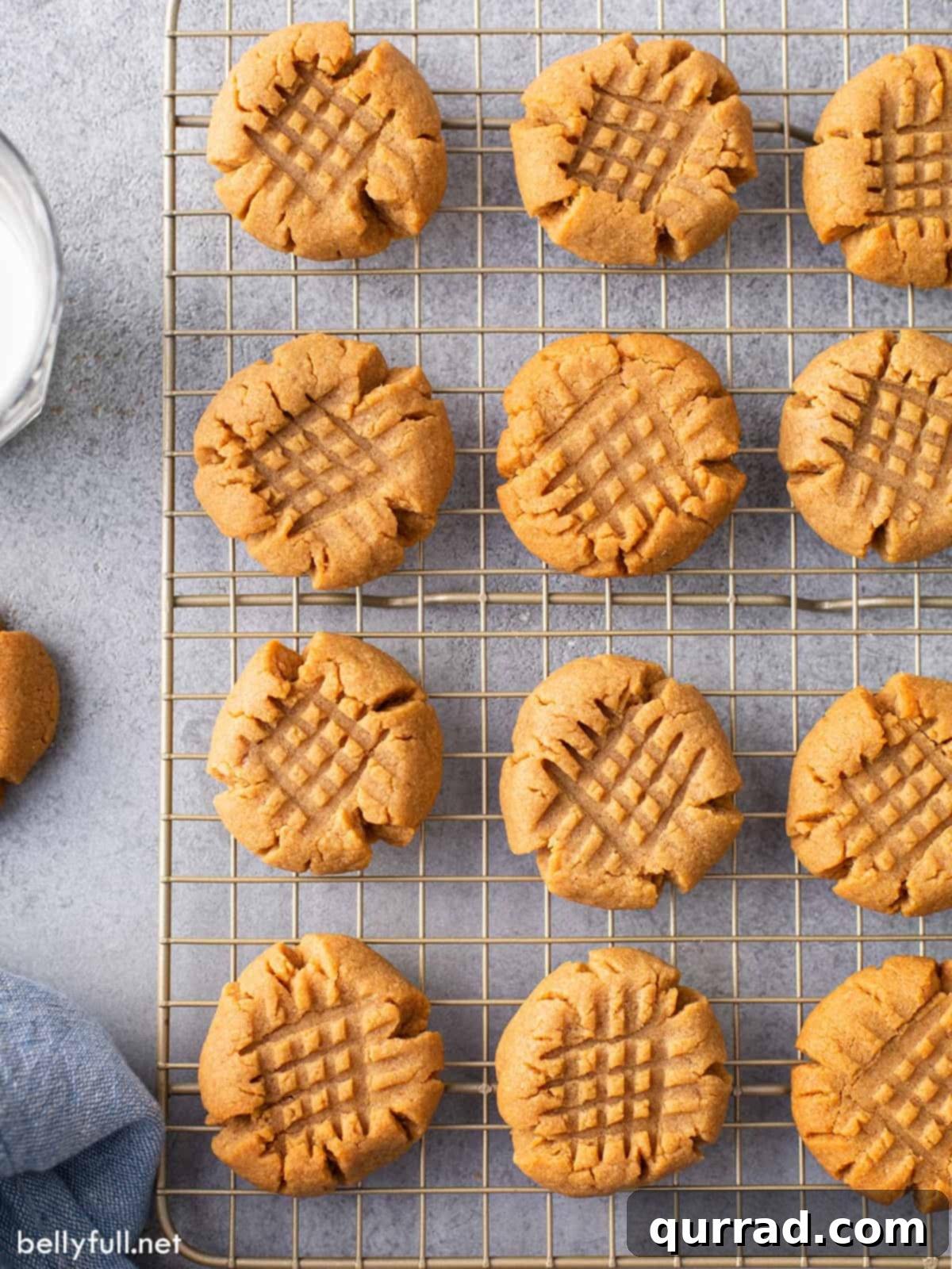 Top-down view of freshly baked peanut butter cookies cooling on a wire rack, showcasing their perfect texture.