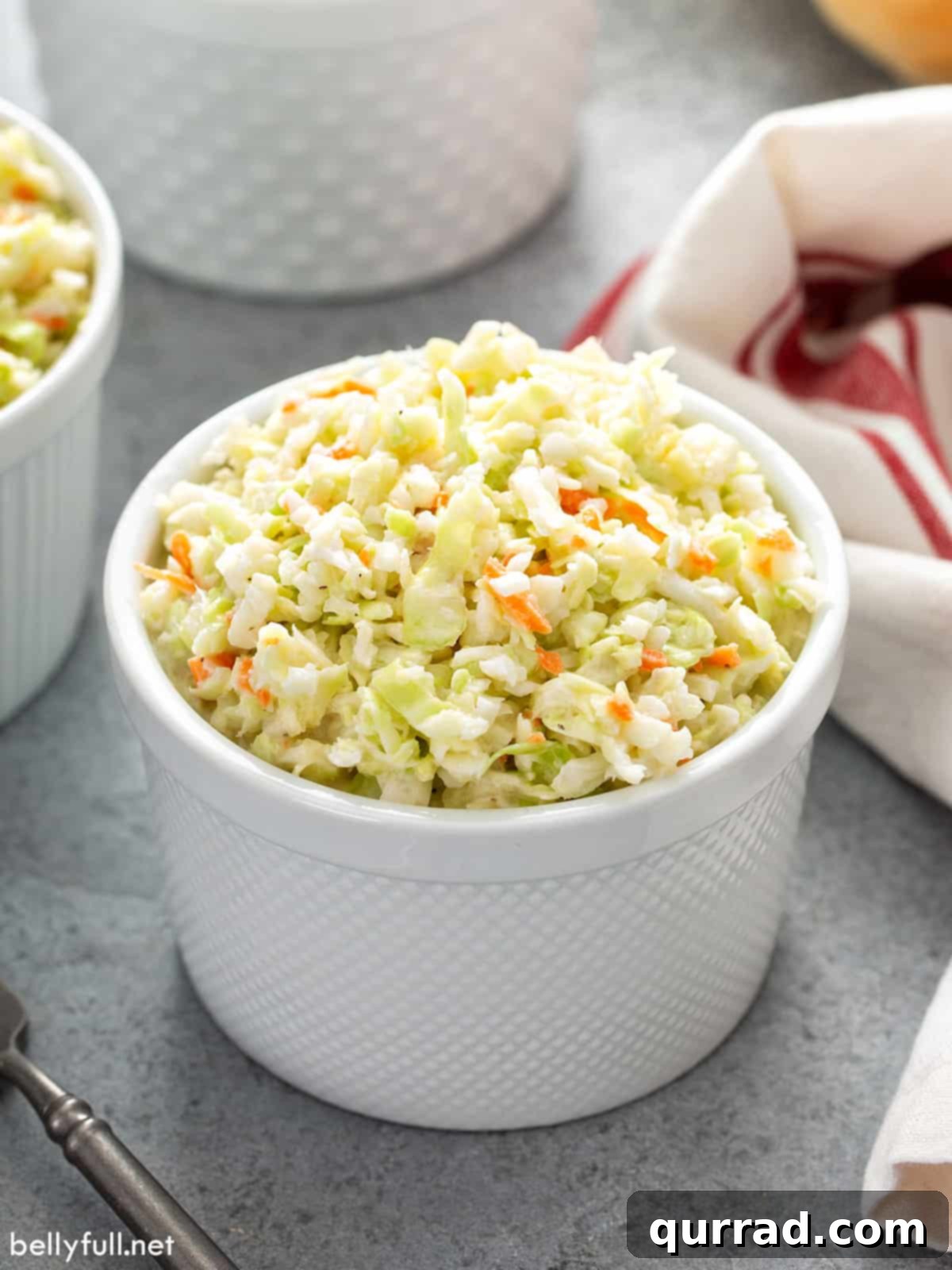 Homemade KFC Coleslaw Secret Revealed 4 KFC coleslaw portion in little white cup, ready for serving at a picnic or gathering