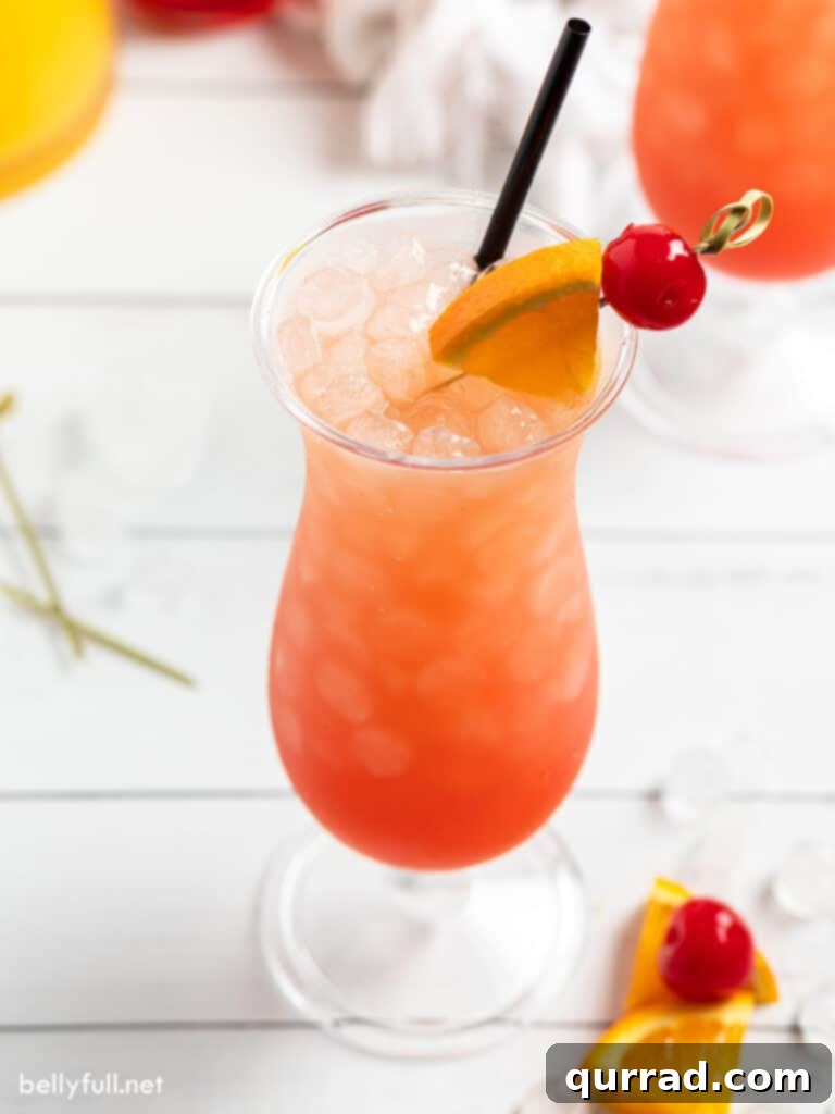 Tropical Sunset Sip 3 Close-up of a Sex on the Beach drink in a hurricane glass, elegantly garnished with a vibrant maraschino cherry and a fresh orange slice, showcasing its inviting colors.