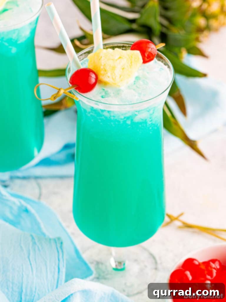 Blue Hawaiian drink in hurricane glass with pineapple garnish