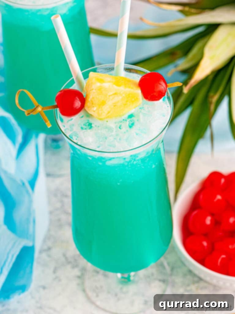 Blue Hawaiian drink garnished with pineapple and a maraschino cherry