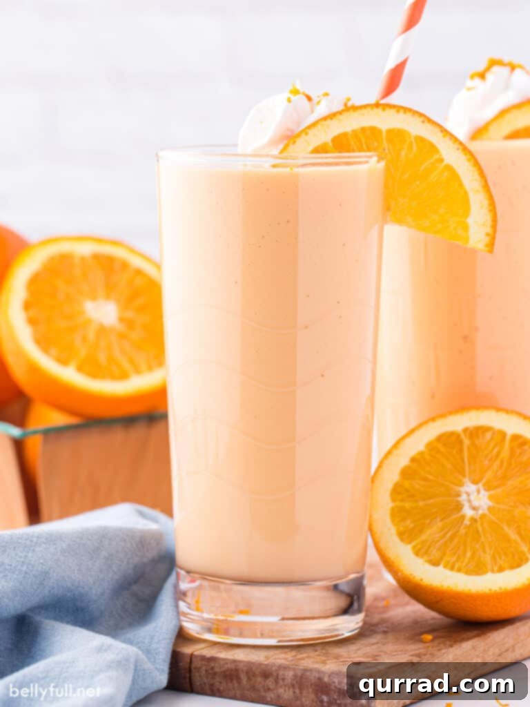 Creamy Orange Dream 3 Close-up of an Orange Julius in a tall glass with a straw, emphasizing its smooth, frothy texture