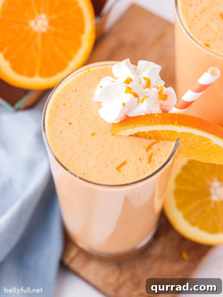 Creamy Orange Dream 4 Overhead view of a creamy Orange Julius in a glass, topped with whipped cream and an orange slice