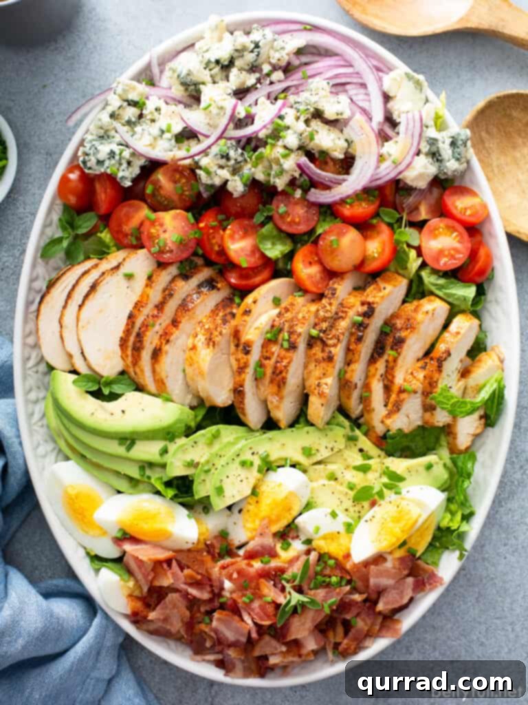 Legendary Cobb Salad 2 A beautifully arranged Cobb Salad on a pristine white serving platter, showcasing its vibrant layers of ingredients.
