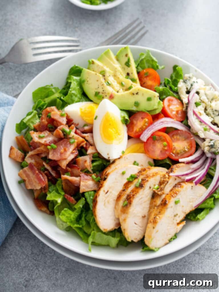 Legendary Cobb Salad 8 Individual serving of Cobb Salad with chicken, bacon, and hard-boiled eggs on a white plate, ready to be enjoyed.