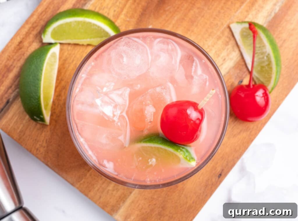 Crimson Tide Refresher 4 An overhead view of a Sea Breeze Cocktail, perfectly garnished with a lime wedge and a cherry, illustrating its vibrant colors.