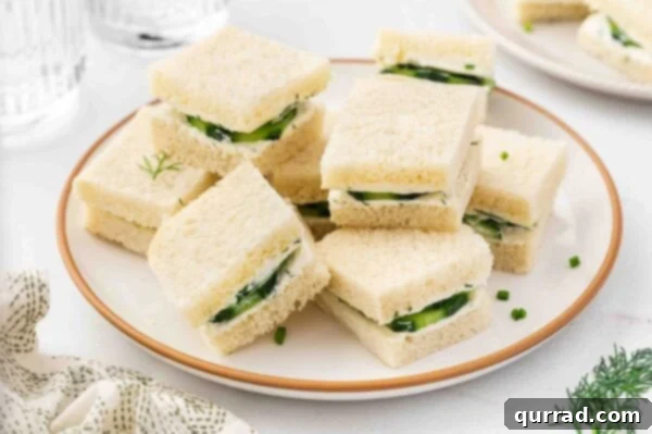 A beautifully arranged plate of stacked cucumber tea sandwiches, ready to be enjoyed.