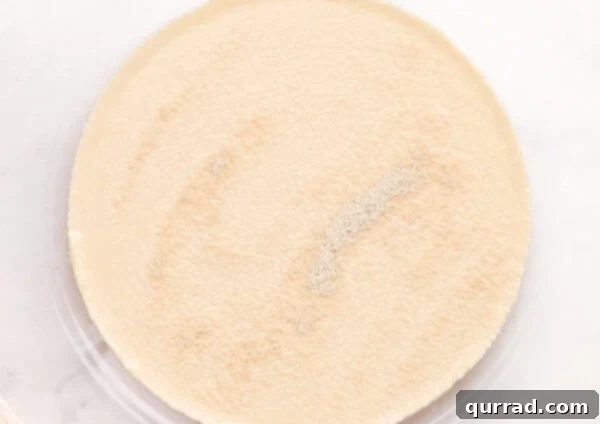 Pillowy Indian Flatbread 2 Proofed yeast mixture in a glass bowl, showing a foamy surface