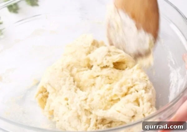 Pillowy Indian Flatbread 5 Shaggy dough mixture in a glass bowl, ready to be kneaded by hand