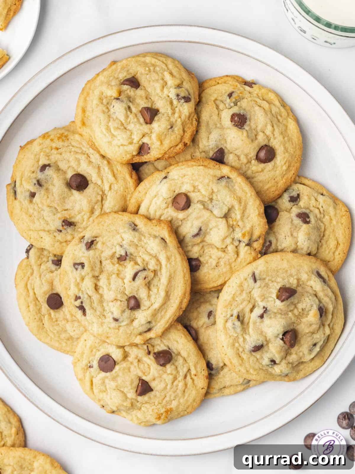 Soft and Chewy Chocolate Chip Pudding Cookies 2 A beautifully arranged plate brimming with freshly baked chocolate chip pudding cookies, golden brown with visible melted chocolate chips.