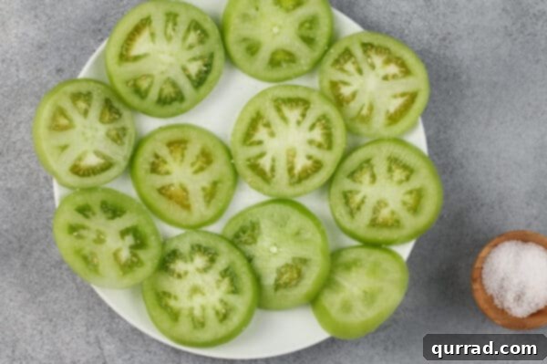 sliced green tomatoes on plate sprinkled with salt
