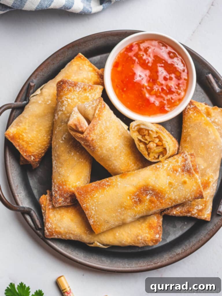 Crispy Air Fryer Egg Rolls 2 overhead shrimp egg rolls on serving platter with sweet chili sauce