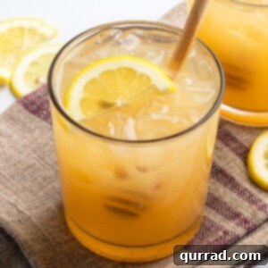 Honey-Kissed Gin Sour 5 Bee's Knees drink with half moon lemon slice and honey drizzler