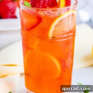 Vibrant Strawberry Lemonade 7 A glass of homemade strawberry lemonade surrounded by lemon slices and strawberries