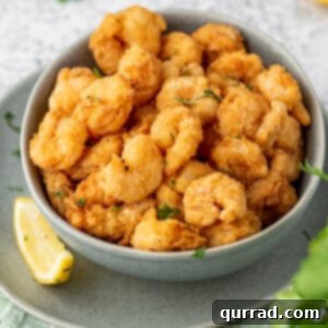 bowl filled with popcorn shrimp with a lemon wedge