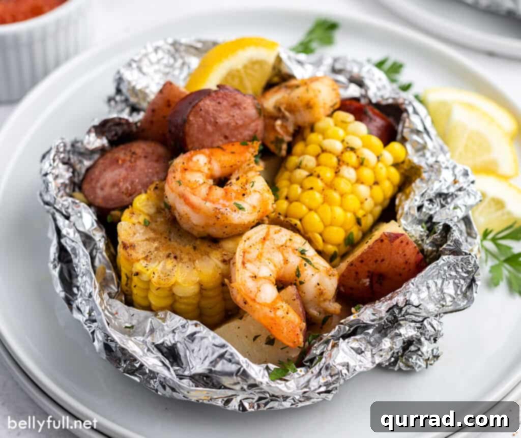 Garlic Butter Shrimp Boil Foil Packs 5 Grilled seafood boil in an open foil packet, showcasing perfectly cooked ingredients with a smoky char