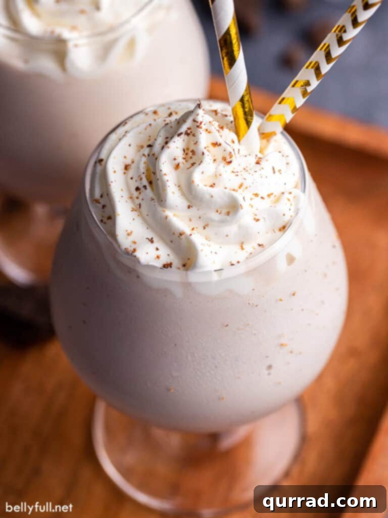 Close-up of a single Brandy Alexander Milkshake, topped with a generous swirl of homemade whipped cream and a dusting of nutmeg.