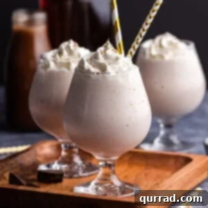 Brandy Alexander Milkshake in dessert glass with gold striped straws