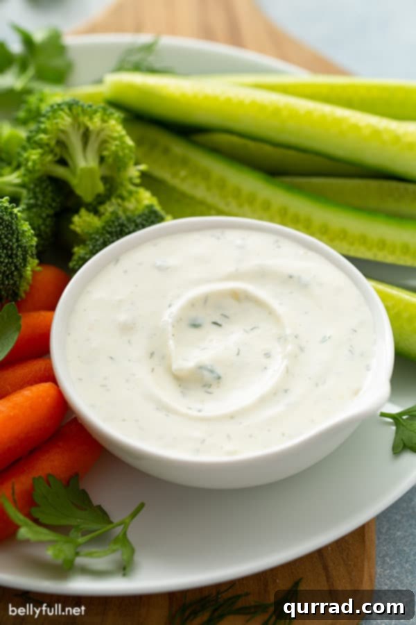 A small bowl of homemade ranch dip with vibrant celery sticks and carrot batons, ready for dipping.