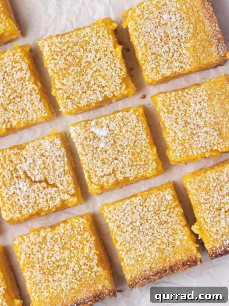 Zesty Lemon Bars 2 overhead close up cut lemon bar squares on parchment paper