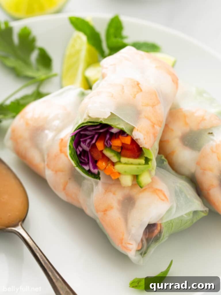 Shrimp spring rolls, some cut in half to show the filling, arranged on a plate