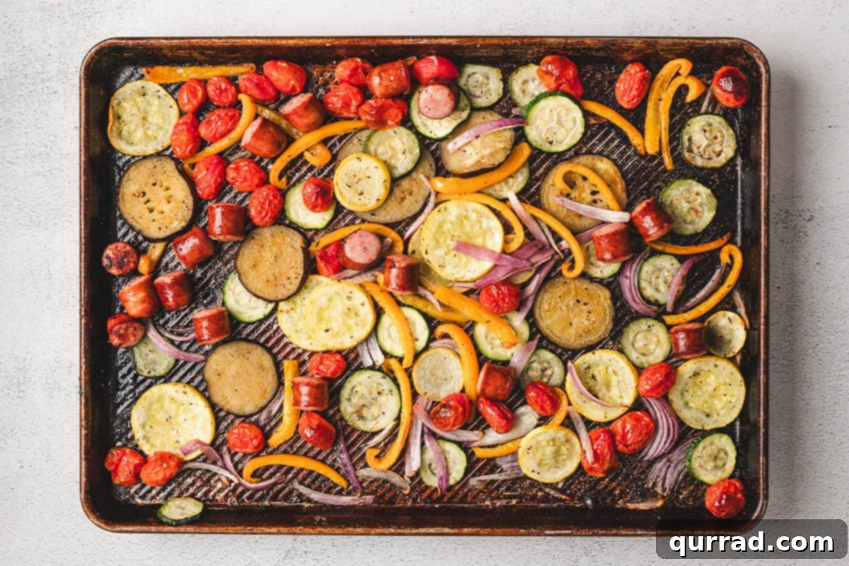 A sheet pan of unbaked ratatouille, thoroughly tossed and arranged in a single layer