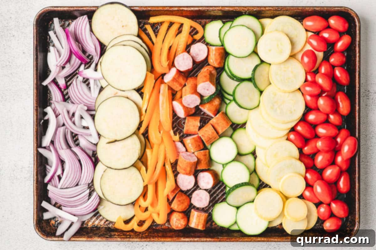 Sliced Japanese eggplant, zucchini, summer squash, bell pepper, and red onion on a cutting board