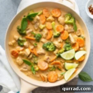 Dreamy Thai Coconut Chicken 5 A skillet of chicken pieces, broccoli and carrots in a creamy coconut sauce