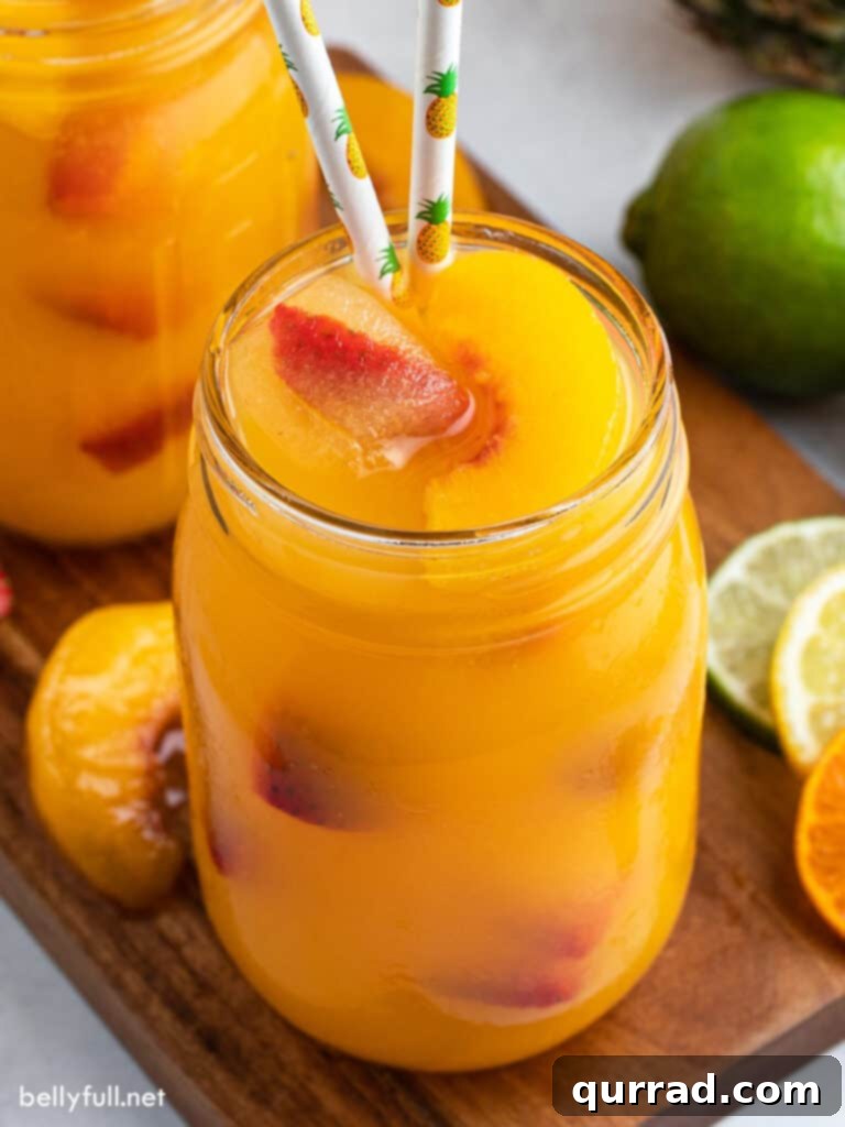 Sunburst Fruit Medley 3 Close-up of fruit punch served in a mason jar, garnished with colorful pineapple straws and fresh fruit slices.