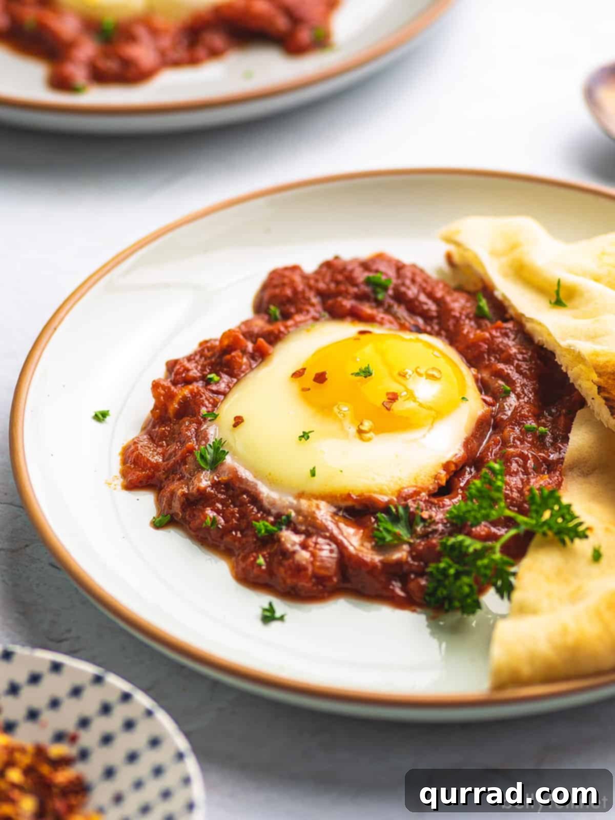 Inferno Baked Eggs 5 A plate of eggs in purgatory garnished with parsley