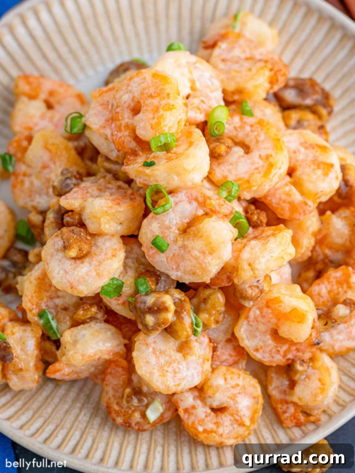 Crispy Honey Walnut Shrimp 2 Overhead view of shrimp in a sweet honey walnut sauce, garnished with scallions