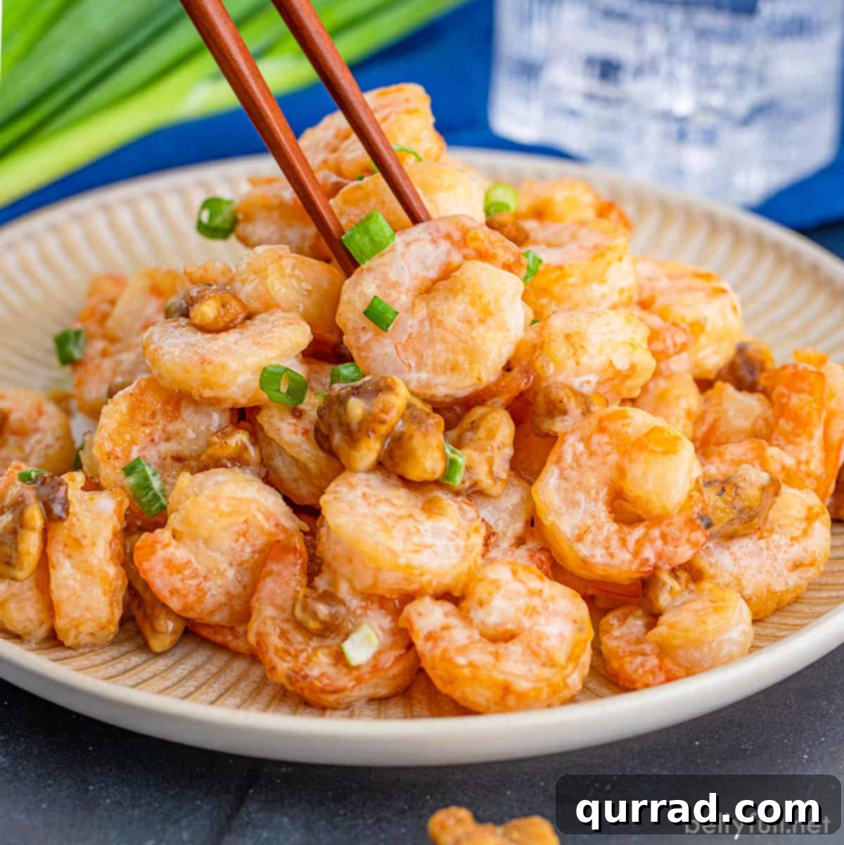 Crispy Honey Walnut Shrimp 3 Chopsticks picking up a piece of perfectly cooked shrimp from a plate of honey walnut shrimp