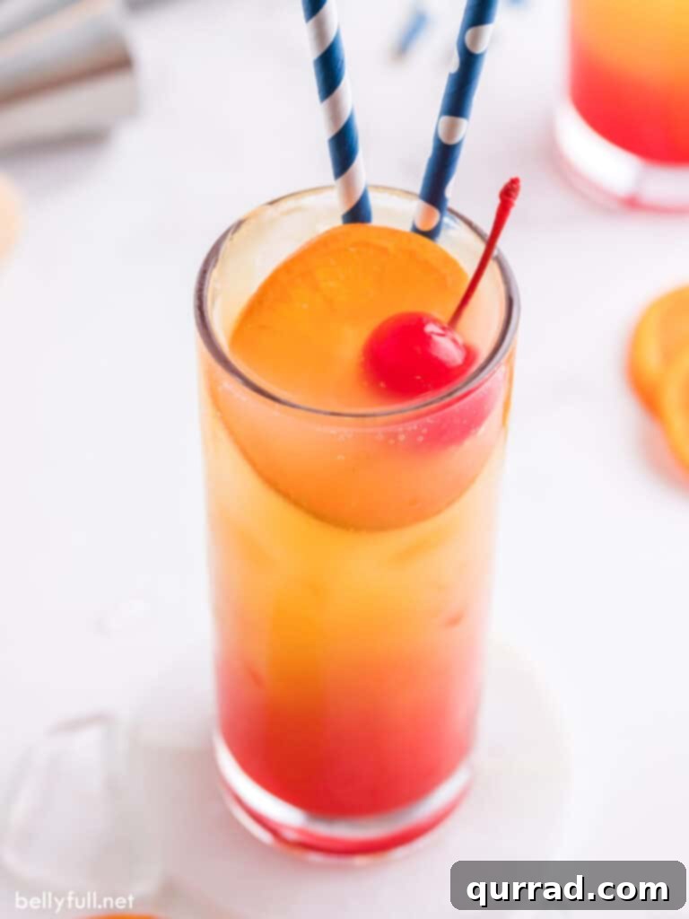Dawn's Golden Kiss 4 Tequila Sunrise cocktail garnished with an orange slice, a maraschino cherry, and straws