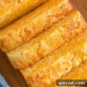 A loaf of cheese bread with four pieces sliced