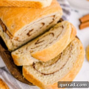 A fresh loaf of cinnamon swirl bread with two slices sliced
