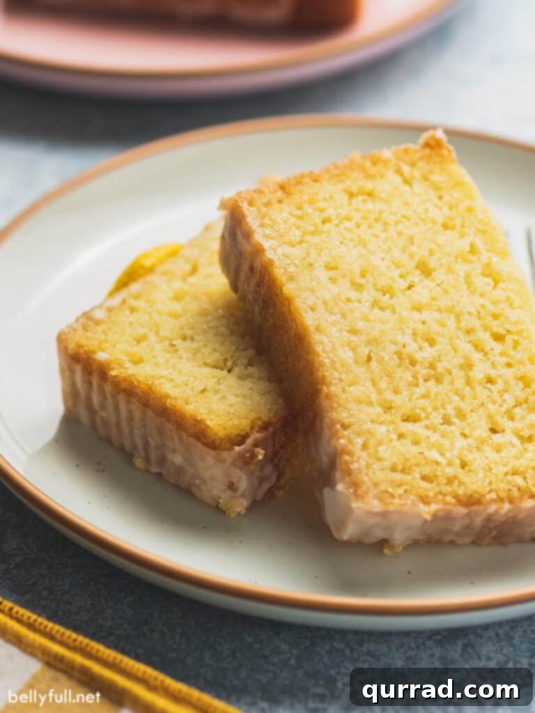 Zesty Lemon Bliss Loaf 2 Two generous slices of moist lemon pound cake, artfully arranged on a plate and topped with a glistening lemon glaze.