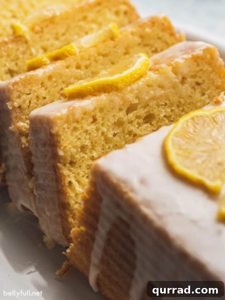 Zesty Lemon Bliss Loaf 5 A close-up shot of a single slice of lemon cake, showcasing its moist texture and topped with a generous amount of glistening icing.