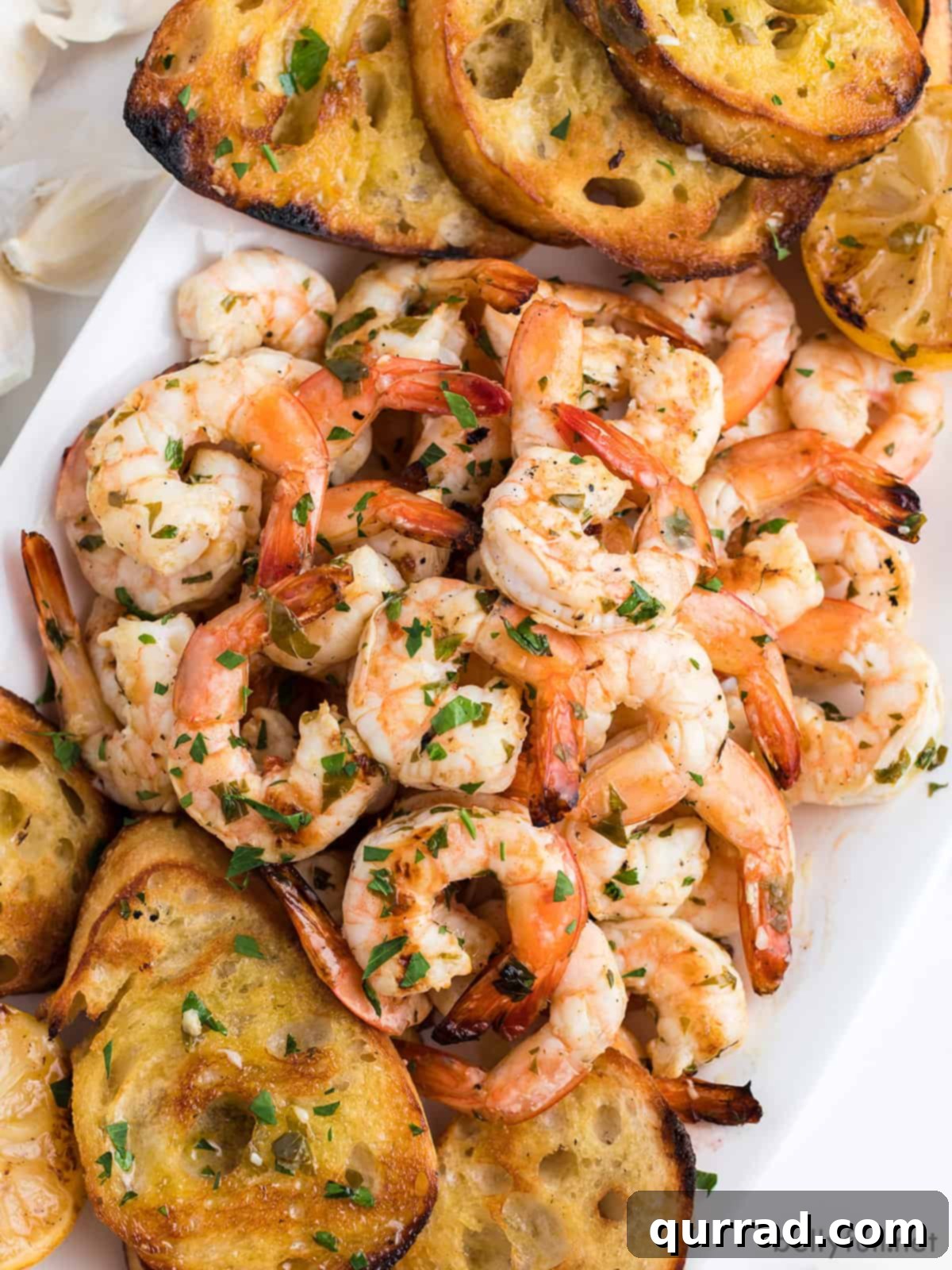 Flame-Kissed Shrimp Scampi 3 Grilled shrimp scampi on a serving tray with baguette slices
