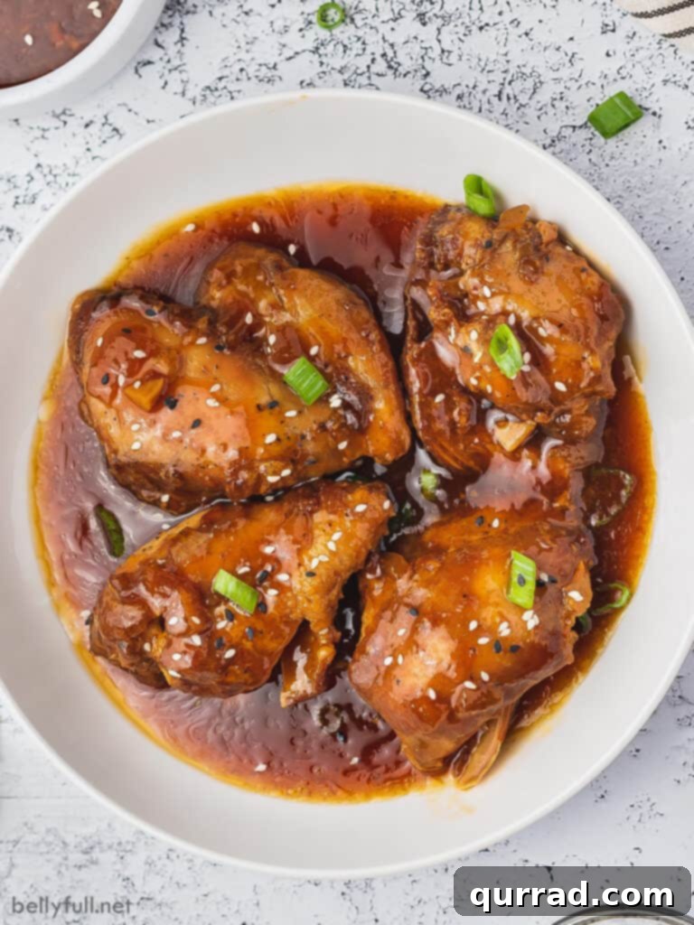 Sweet and Sticky Honey Garlic Chicken 2 overhead honey garlic chicken thighs coated in sauce on white plate