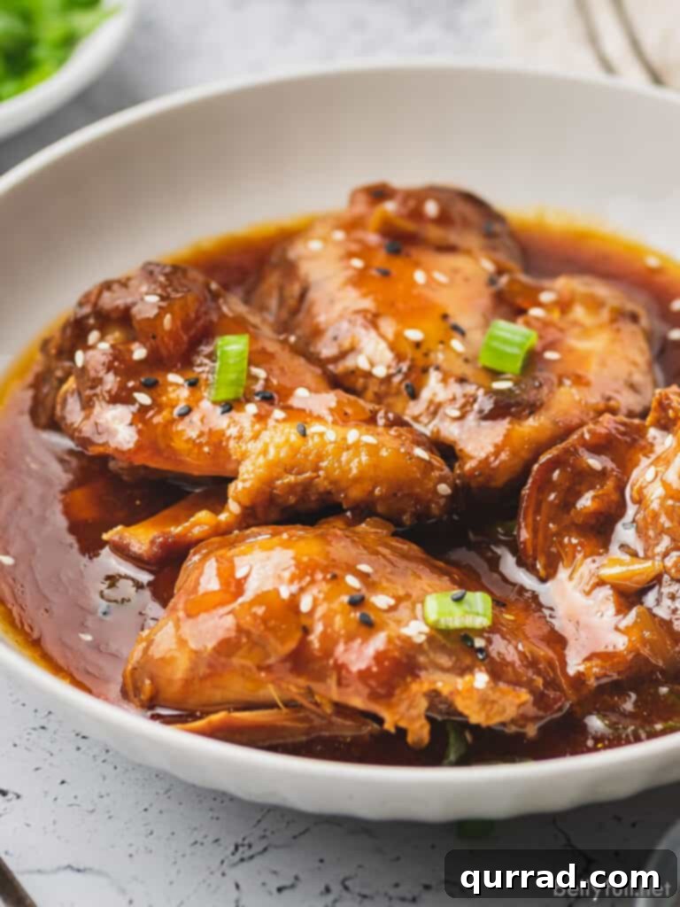 Sweet and Sticky Honey Garlic Chicken 3 glazed chicken thighs coated in sauce in white bowl