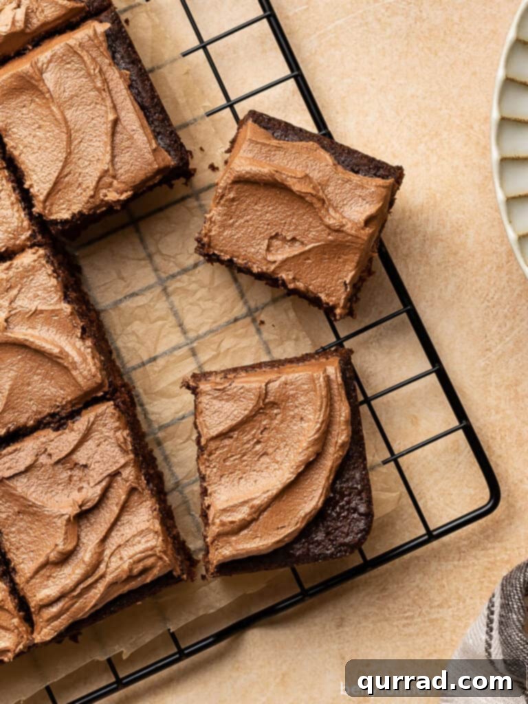 Velvet Chocolate Mayonnaise Cake 2 Overhead view of sliced squares of frosted chocolate mayonnaise cake on a wire cooling rack, ready to serve.