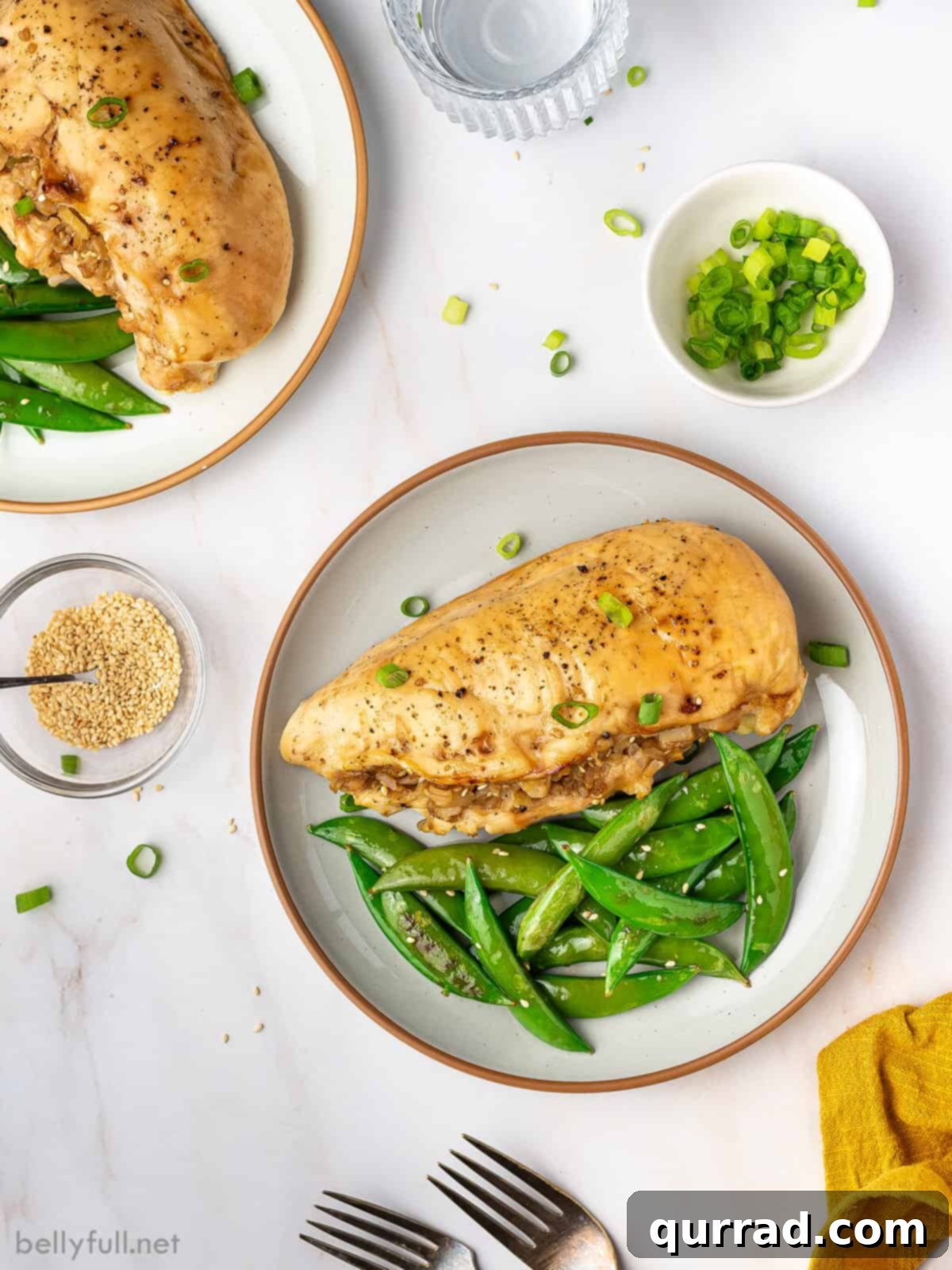 Fragrant Asian Rice Stuffed Chicken 4 A perfectly sliced Asian rice stuffed chicken breast revealing the savory rice filling with water chestnuts and scallions, served alongside vibrant green beans on a white plate.