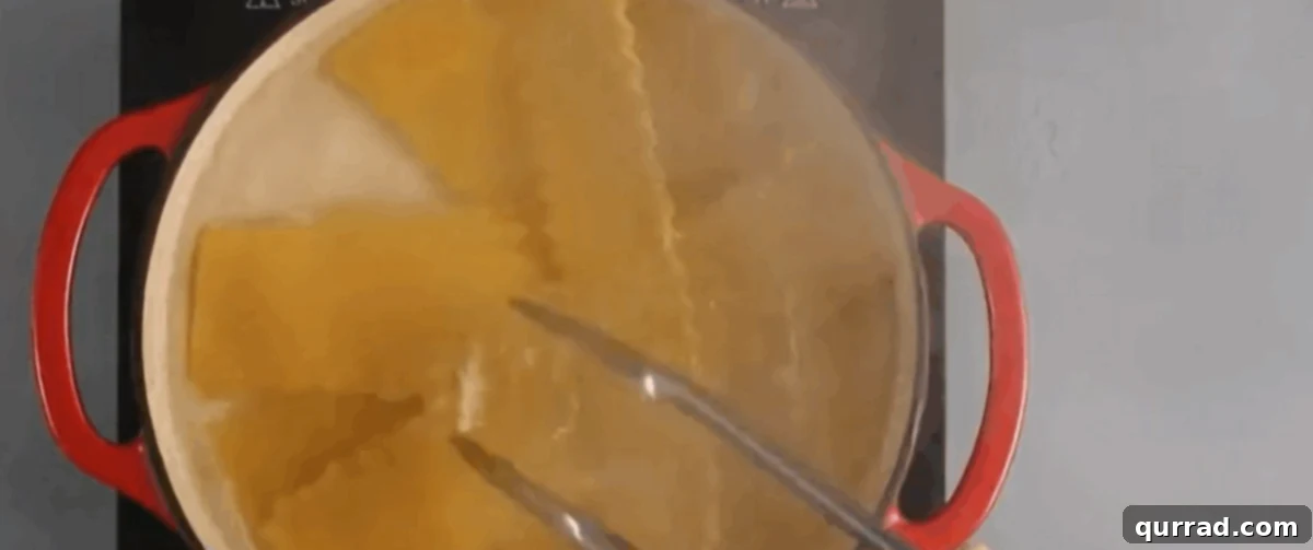 Cooking lasagna noodles in a red pot. 