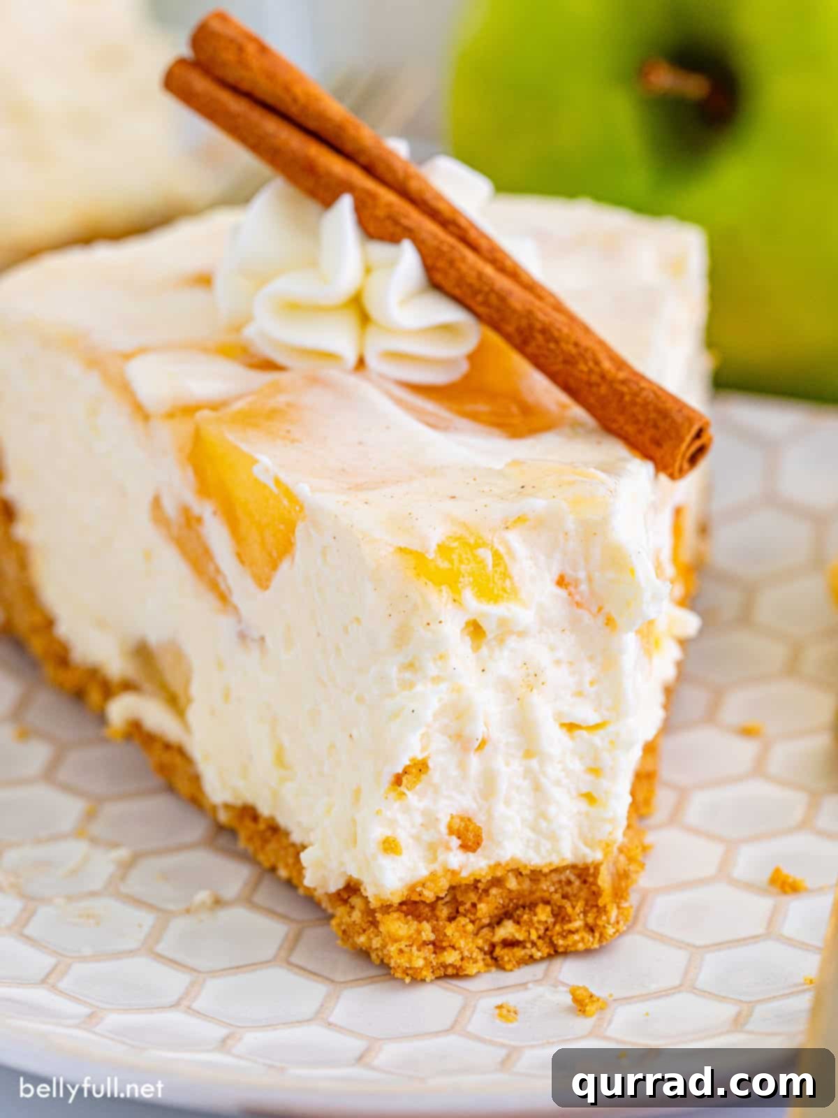 No Bake Apple Pie Cheesecake 2 A slice of apple pie cheesecake on a plate with a bite missing, garnished with caramel sauce.